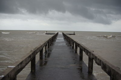 Wooden pier on sea against sky