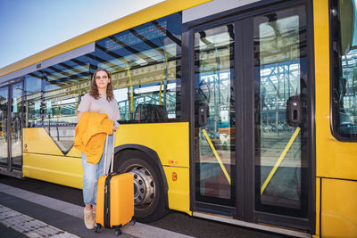 Portrait of woman with yellow umbrella on bus