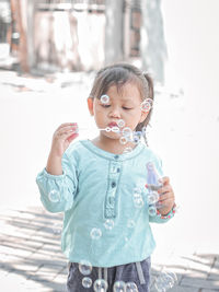 Cute girl holding ice cream standing outdoors