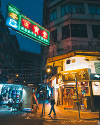 People walking on illuminated street at night