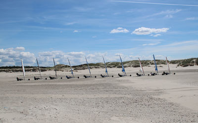 People enjoying beach buggy ride against sky