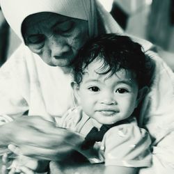 Close-up of grandmother feeding cute granddaughter at home