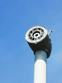 Low angle view of communications tower against blue sky