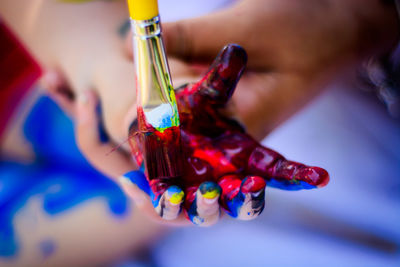 Close-up of hand holding multi colored glass