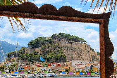 Boats moored against castle seen through frame