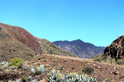 Scenic view of mountains against clear blue sky