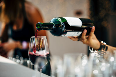 Close-up of hand pouring wine in glass