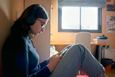 Side view of young woman using mobile phone