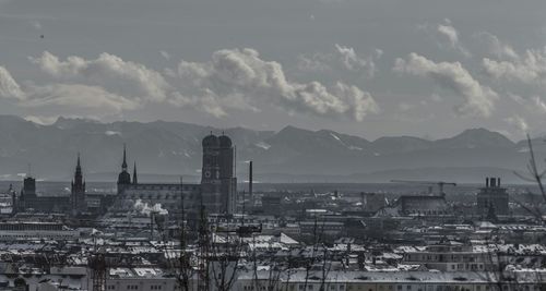 View of cityscape against cloudy sky