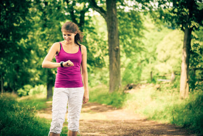 Woman running on mobile phone in forest