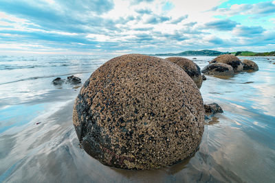 Rocks on beach against sky