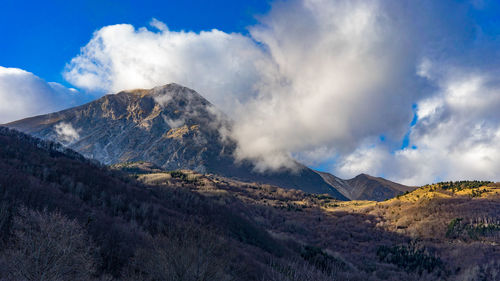 Scenic view of snowcapped mountains against cloudy sky