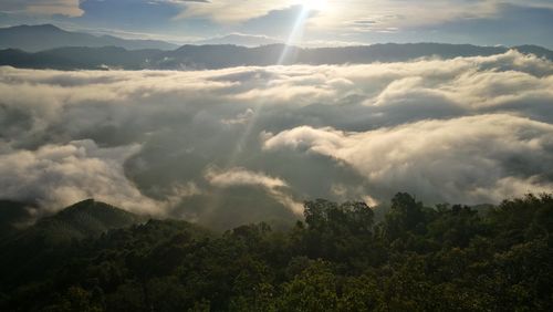 Aerial view of clouds over mountain against sky