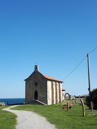 Church by building against clear blue sky