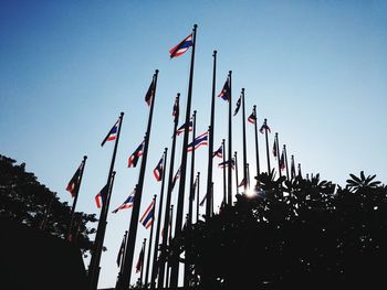 Low angle view of flags against clear sky