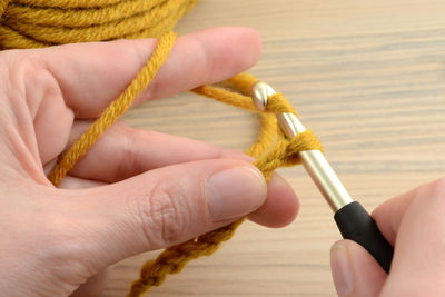 Cropped image of person knitting wool