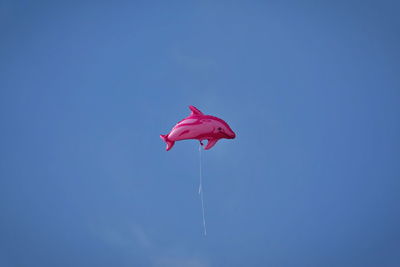 Low angle view of balloon against clear blue sky