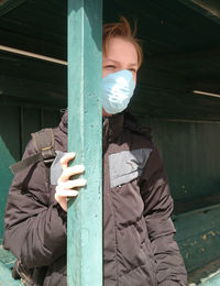 Midsection of man holding umbrella while standing on wooden door