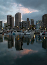 Honolulu skyline reflected in the marina harbor at sunrise