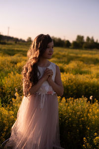 Teen standing on field against sky