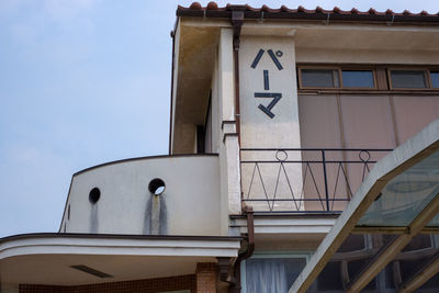 Low angle view of text on building against sky