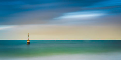 Lighthouse by sea against sky