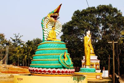 Statue of buddha against trees