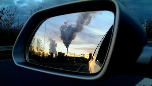 Reflection of clouds in side-view mirror