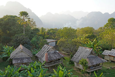 Wooden bungalows in the trees, mountains in the background