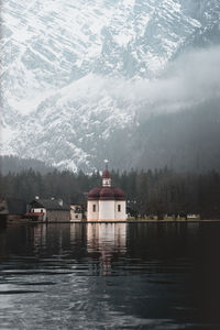 Scenic view of lake by buildings against mountain