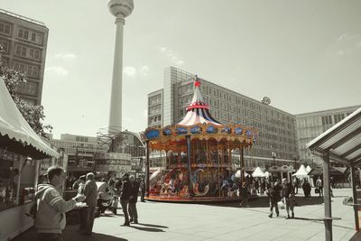 People in amusement park against clear sky