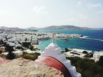 Aerial view of cityscape by sea against sky