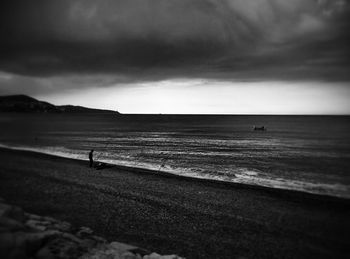 Scenic view of beach against cloudy sky