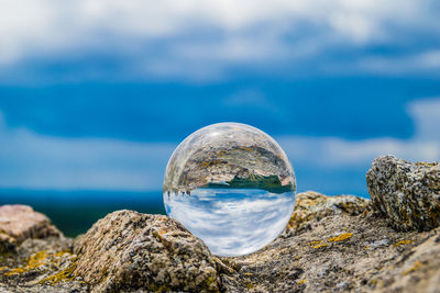 Close-up of rocks in sea against sky