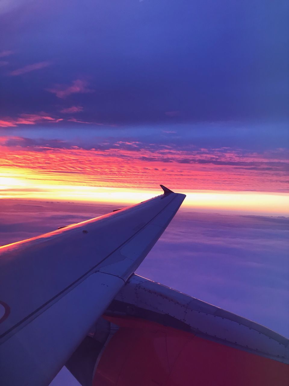 AIRPLANE FLYING OVER ORANGE SKY