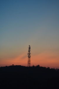Silhouette of electricity pylon against sky during sunset
