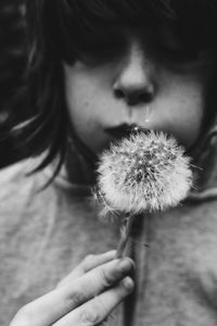 Close-up of woman holding dandelion flower