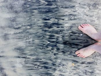 Low section of woman standing in water