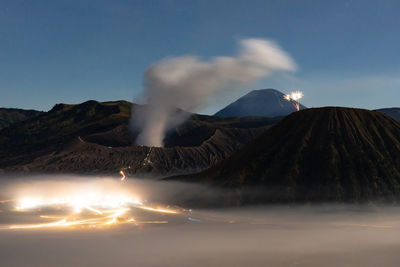 Smoke emitting from volcanic mountain against sky