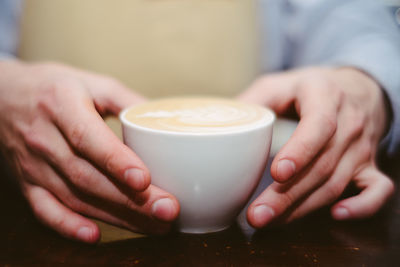 Close-up of hand holding coffee cup