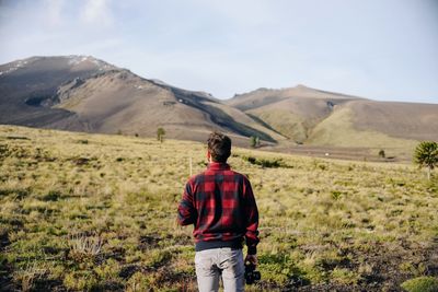 Rear view of man standing on arid landscape