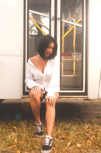 Full length of woman sitting by window