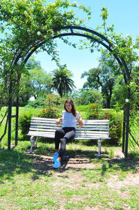 Woman sitting on bench in park