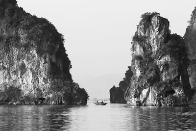 Rock formations in sea against clear sky