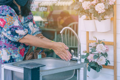Woman standing by potted plant