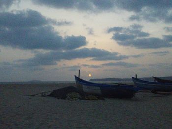 Boats in sea at sunset