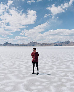 Full length of man standing on shore against sky