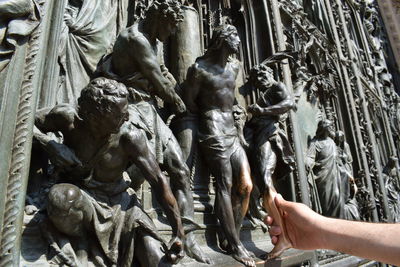 Cropped image of hand holding statue