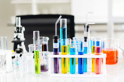Multi colored liquids in laboratory glassware on table