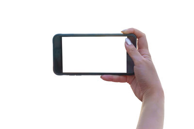 Low angle view of hand holding smart phone against white background